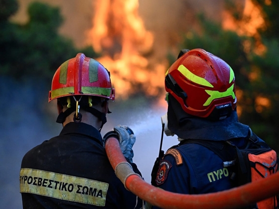 A görög tűzoltók azt remélik, hogy megfékezhetik a tüzet Athén közelében, mivel az enyhülő szél lehetővé teszi a vízibombázó repülőgépek használatát